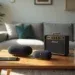 Modern living room with two black Meilleure Enceinte Bluetooth, a Marshall amplifier, smartphone, and glasses on a wooden coffee table