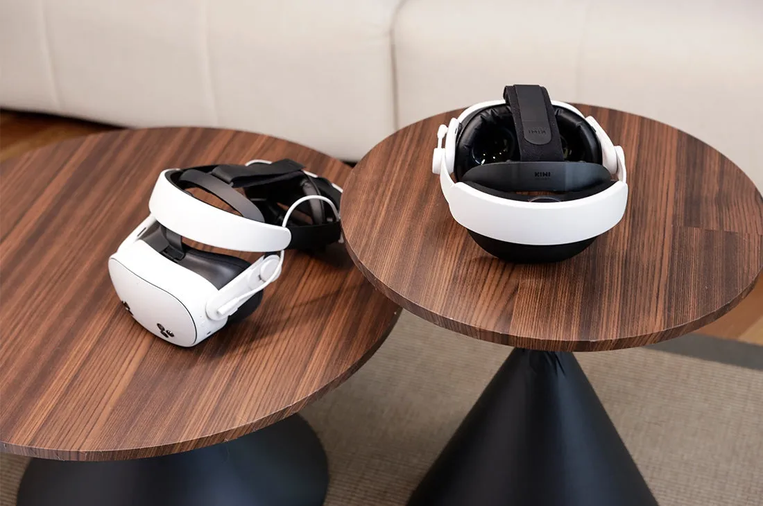 Meta Quest 3S and Apple Vision Pro VR headsets displayed on two round wooden tables for comparison.