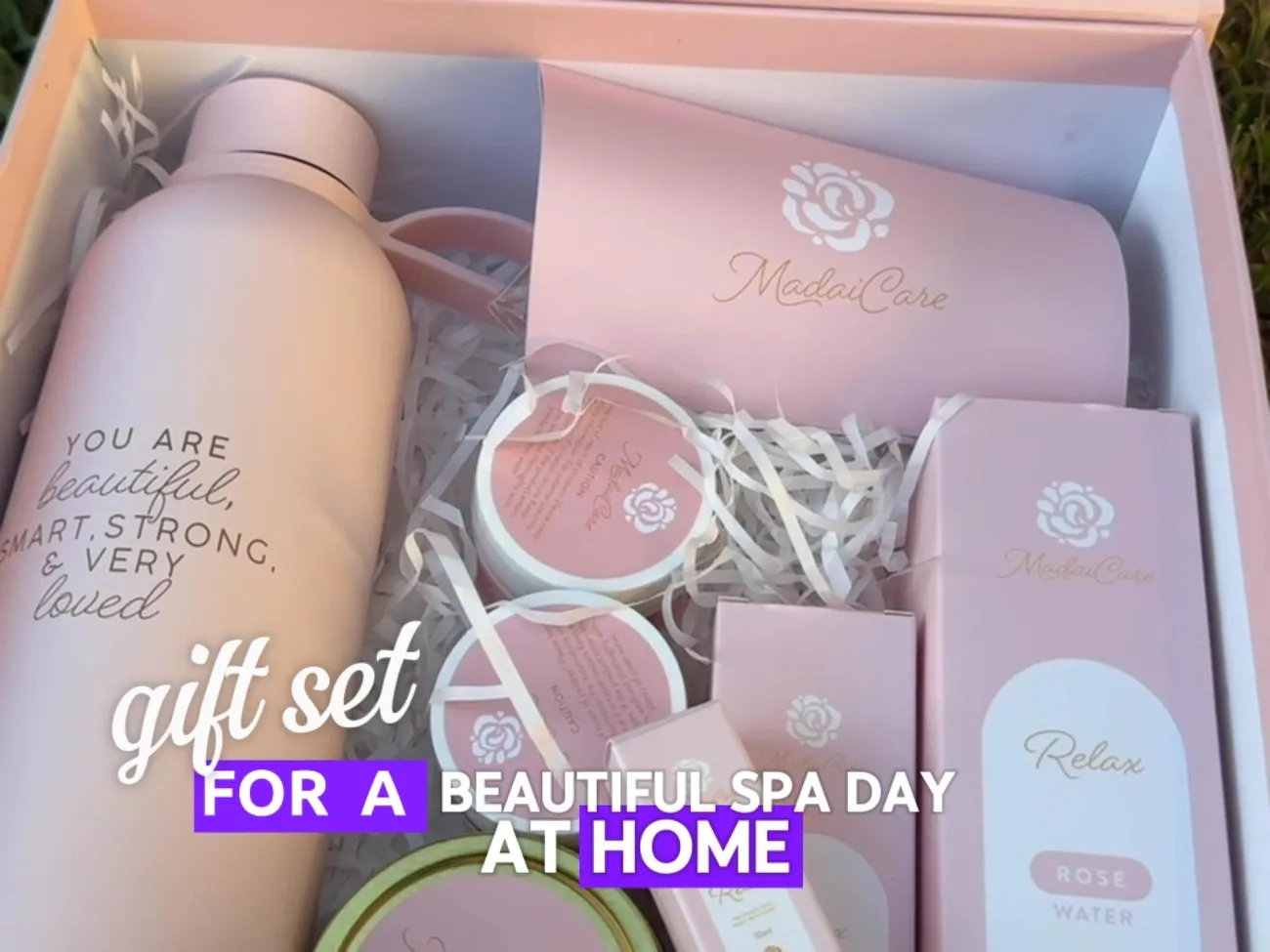 Luxury pink spa gift basket including water bottle, mug, rose water, and skincare products for a relaxing day at home.