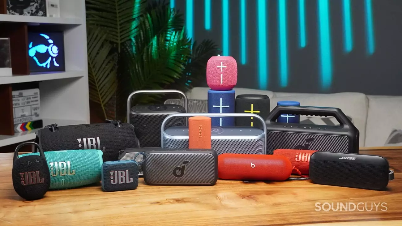 A variety of top Bluetooth speakers from brands like JBL, Bose, and Sonos displayed on a wooden table for 2025 summer picks.